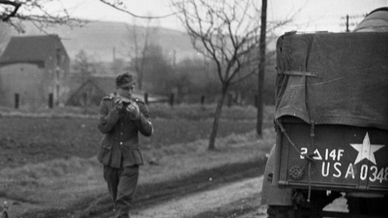 Ankündigungsbild zur Digitalen Ausstellung des Stadtarchivs zum Kriegsende vor 80 Jahren Barrierefreier Text: Neben dem abgesetzten Text „erinnern, gedenken, gestalten …“ in der linken, oberen Ecke des Bildes und der Überschrift „80 Jahre Kriegsende in Lemgo“ zeigt das Archivbild ein US-amerikanisches Militärfahrzeug und einen Soldaten auf einer Landstraße. Im Hintergrund des Bildes ist vermutlich eine Mühle und Hügel zu erkennen.